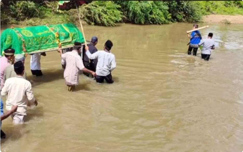 Tidak Ada Jembatan, Warga Didesa Ini Terpaksa Menyeberangi Sungai Sambil Membawa Keranda Jenazah