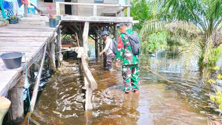 Babinsa dan Babhinkamtibmas Pantau Lokasi Rawan Banjir di Desa Air Balui