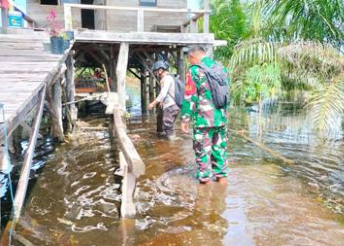 Babinsa dan Babhinkamtibmas Pantau Lokasi Rawan Banjir di Desa Air Balui